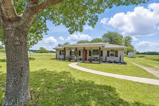 a front view of a house with a yard table and chairs