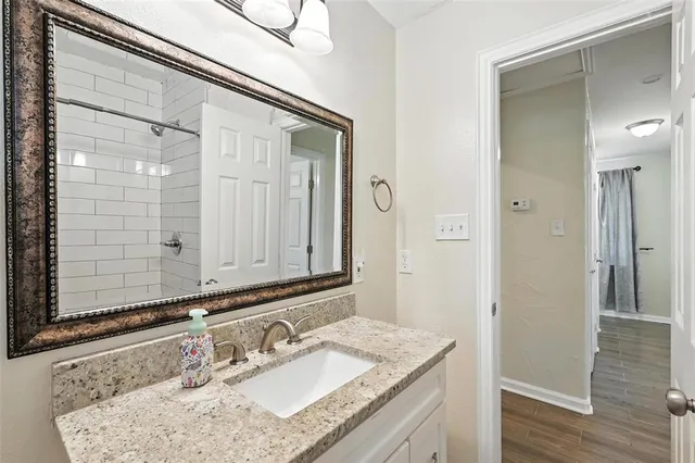 a bathroom with a granite countertop toilet a sink and mirror