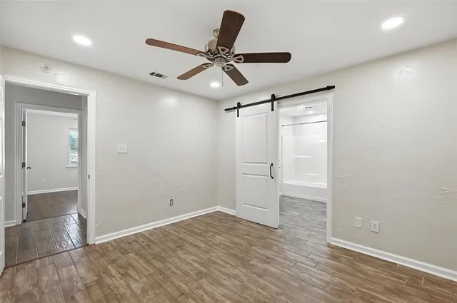 a view of empty room with wooden floor