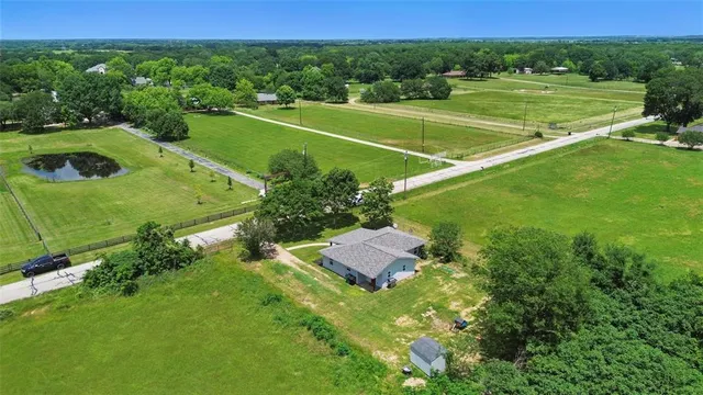 an aerial view of a residential houses with yard