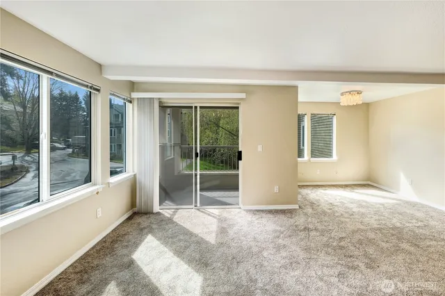 a view of an empty room with glass door and balcony