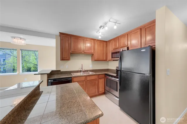 a kitchen with a refrigerator a sink and cabinets