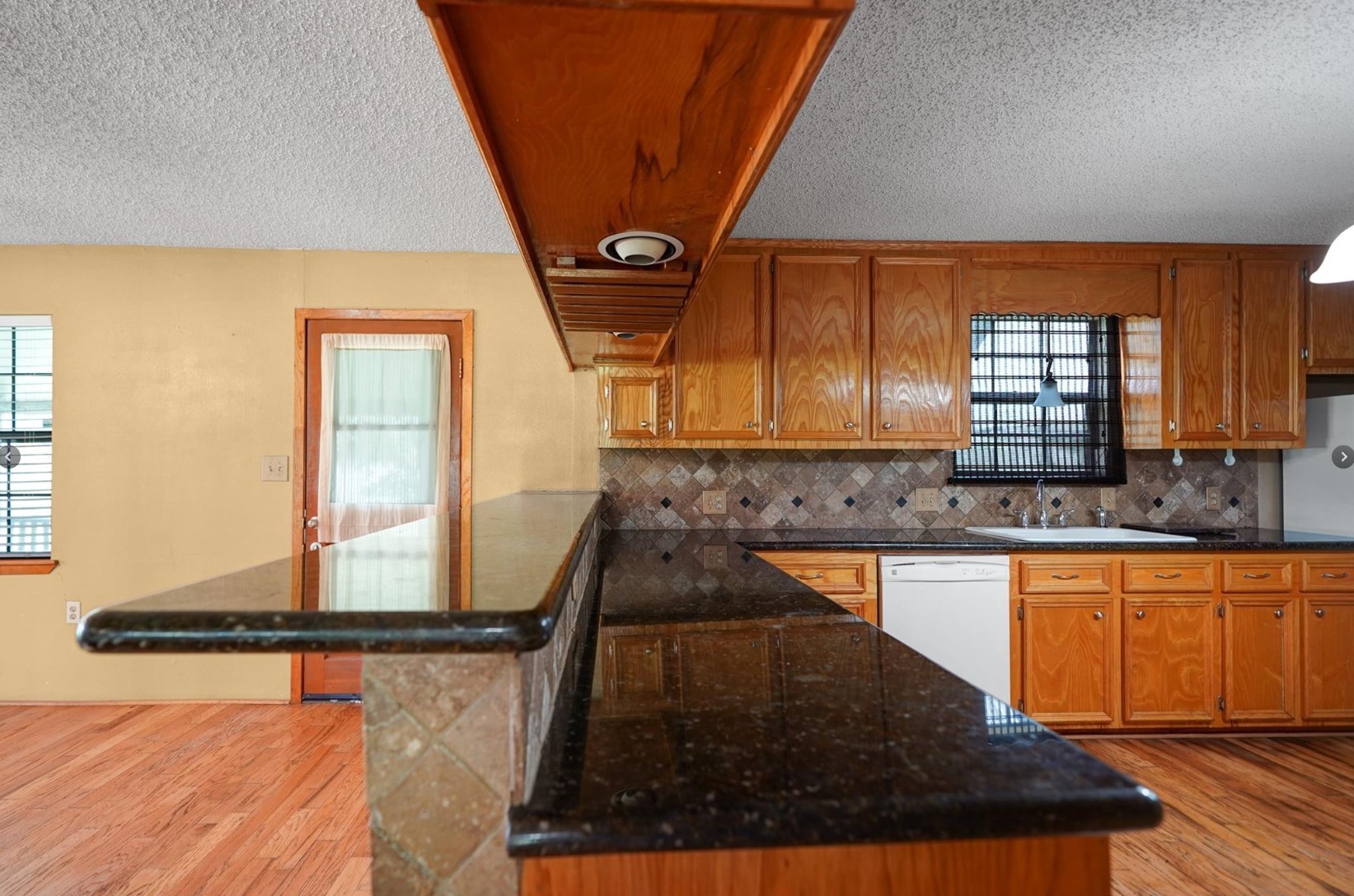 22855 East Martin Drive Porter, TX 77365 - Photo 7 of 22 a kitchen with kitchen island granite countertop a sink a counter top space and cabinets