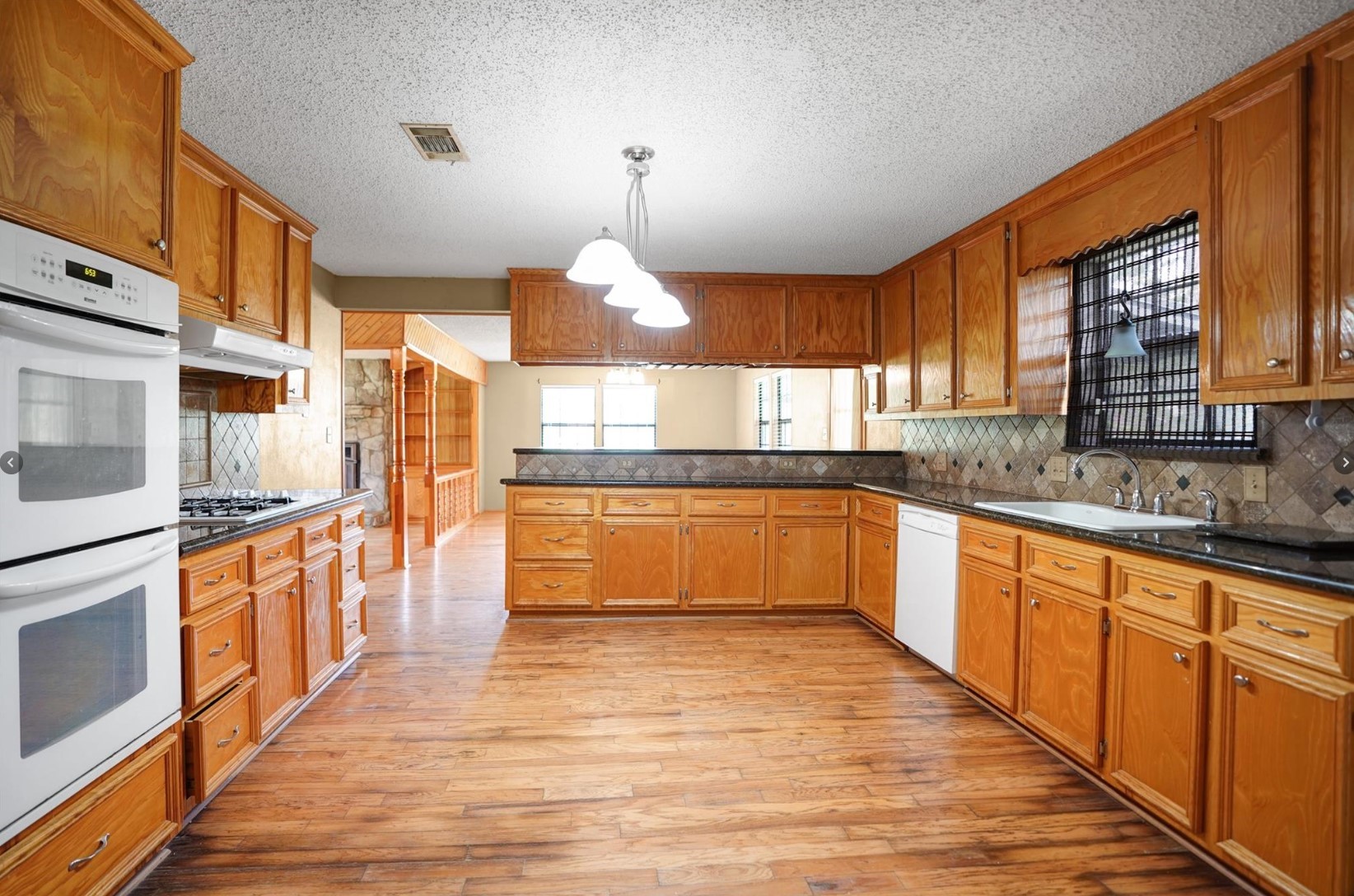 22855 East Martin Drive Porter, TX 77365 - Photo 8 of 22 a large kitchen with stainless steel appliances granite countertop a stove and a sink
