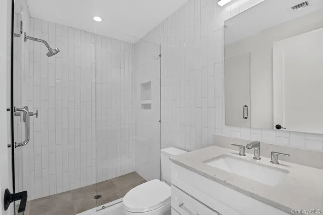 a bathroom with a granite countertop sink toilet a mirror and shower