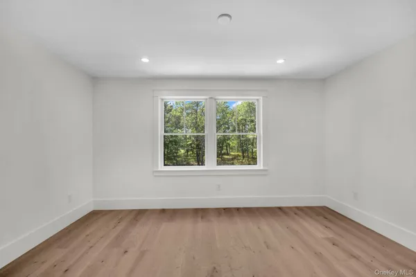 an empty room with wooden floor and window