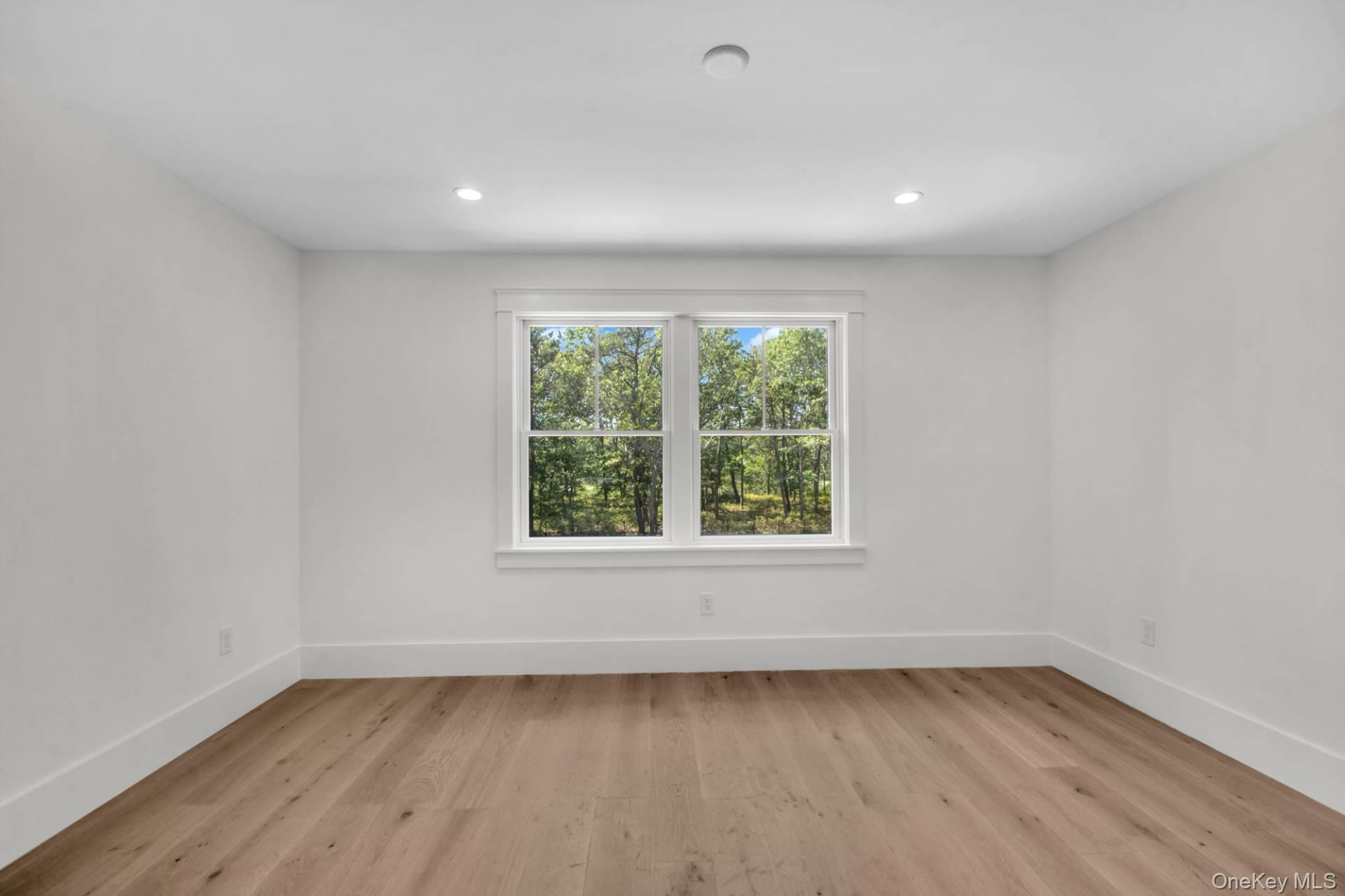 95 North Summit Boulevard Westhampton, NY 11977 - Photo 17 of 21 an empty room with wooden floor and window