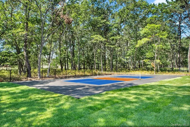 a view of swimming pool with large trees and lawn chairs