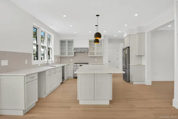 a large kitchen with stainless steel appliances kitchen island granite countertop a sink and cabinets