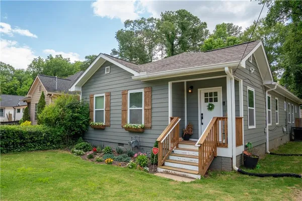 a front view of a house with a garden and plants