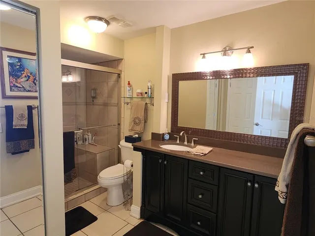a bathroom with a double vanity sink toilet mirror and shower
