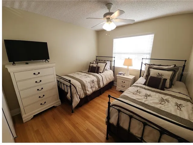 a bedroom with two beds and a flat screen tv