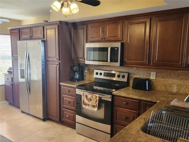 a kitchen with stainless steel appliances granite countertop a stove a refrigerator and a microwave