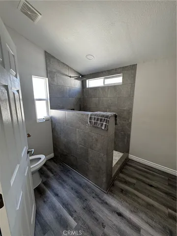 a bathroom with a granite countertop toilet and a shower