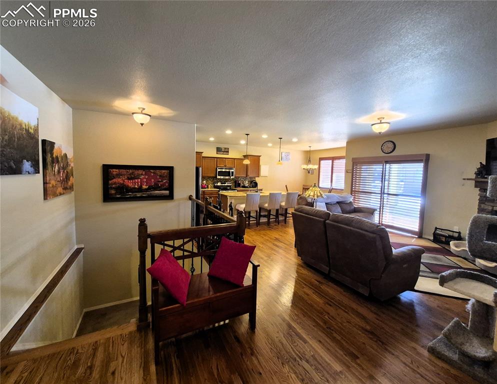 7619 Eagle Feather Point Colorado Springs, CO 80923 - Photo 4 of 23 a living room with furniture kitchen view and a flat screen tv