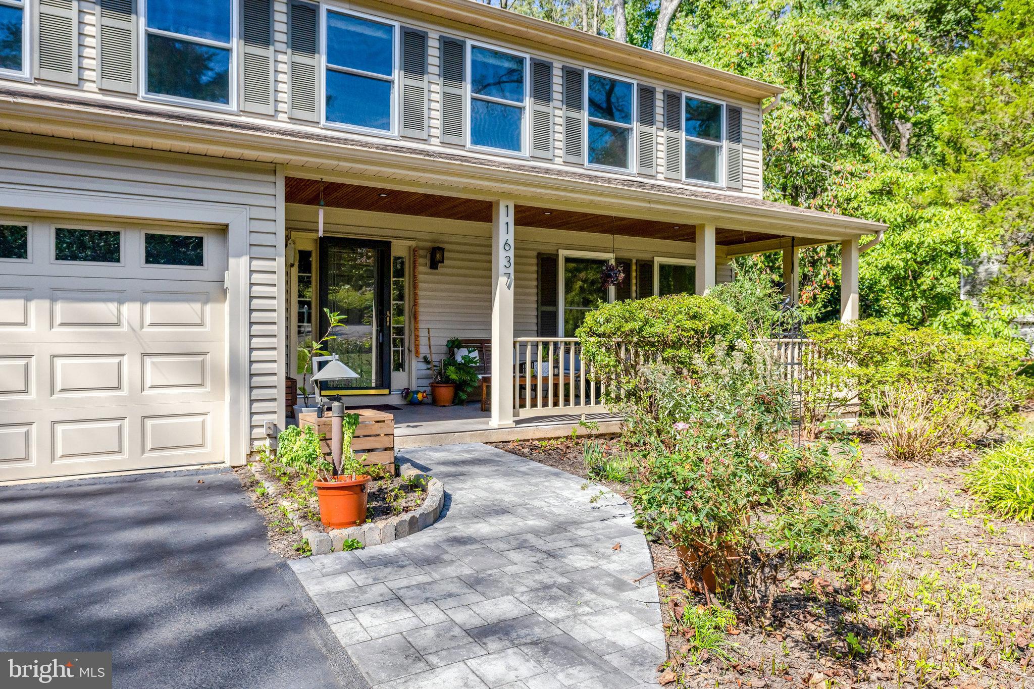 11637 Quail Ridge Court Reston, VA 20194 - Photo 1 of 46 front view of a brick house with a large windows and flower plants
