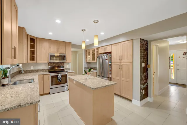 a kitchen with stainless steel appliances granite countertop a sink a stove and a refrigerator