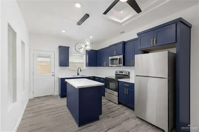 a kitchen with stainless steel appliances granite countertop a refrigerator a sink dishwasher a stove with wooden cabinets and floor