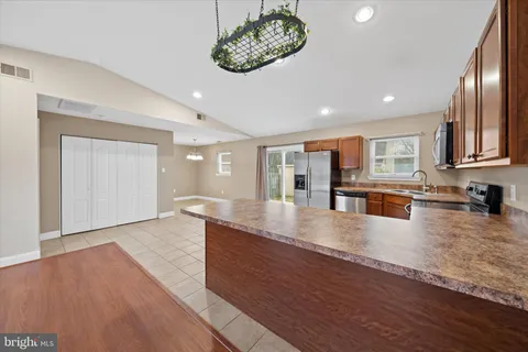 a large kitchen with stainless steel appliances granite countertop a large counter top and a wooden floors