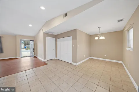 an empty room with wooden floor and natural light
