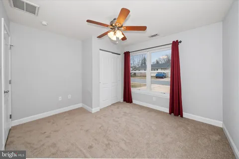an empty room with window and a ceiling fan