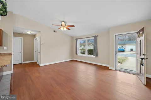 an empty room with wooden floor and a window