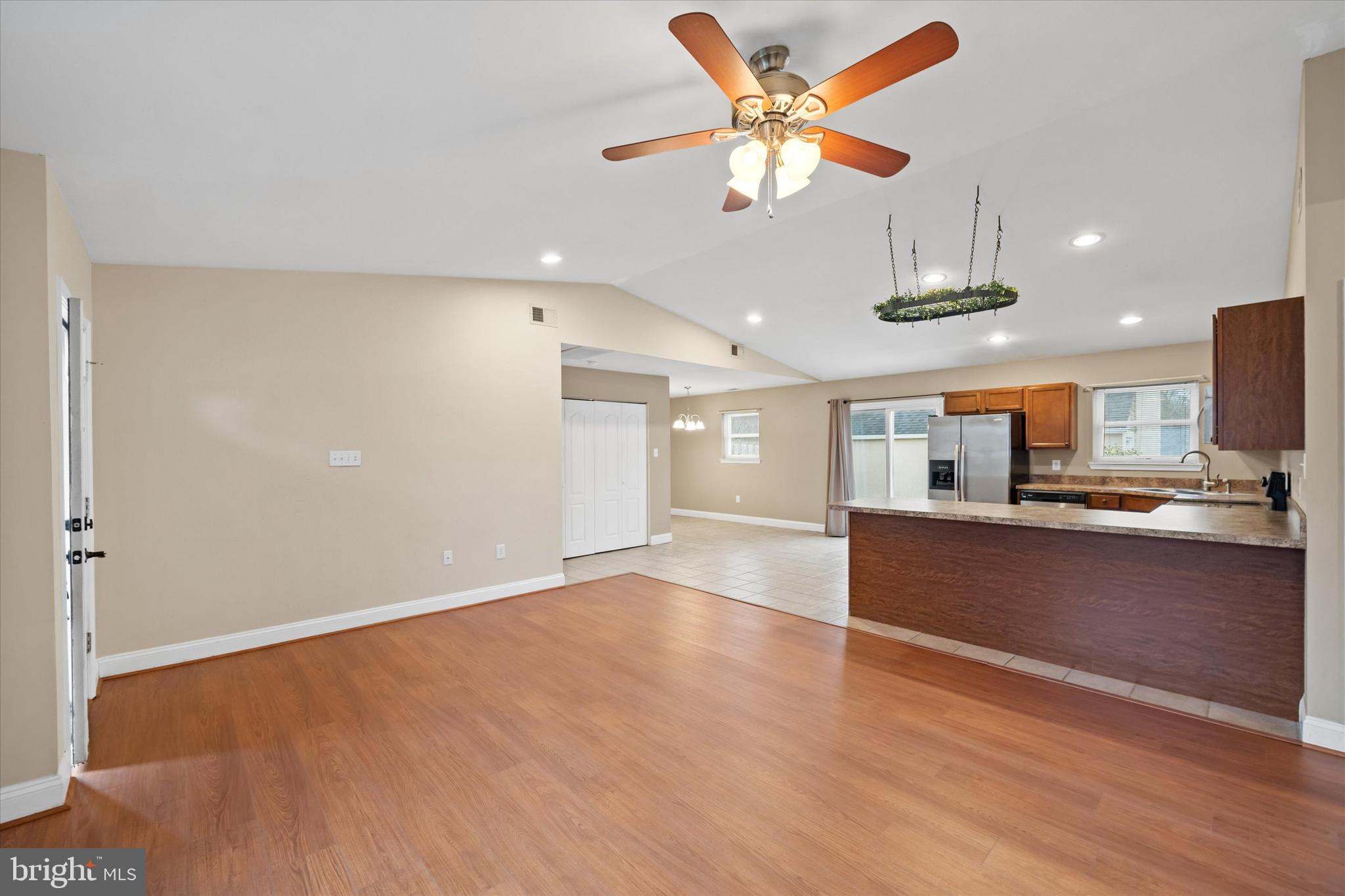 17 Gogh Circle Newark, DE 19702 - Photo 9 of 34 an empty room with wooden floor a ceiling fan and kitchen view