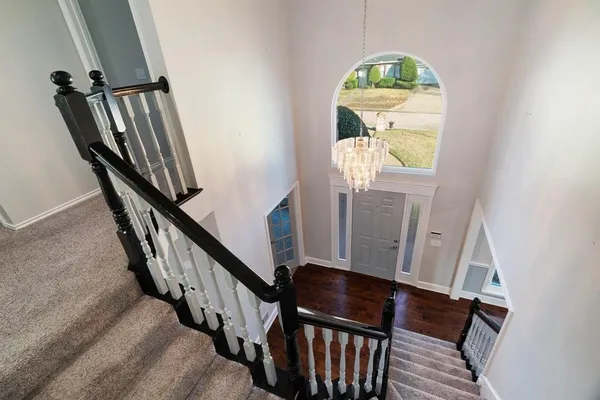 a view of staircase with railing and a window
