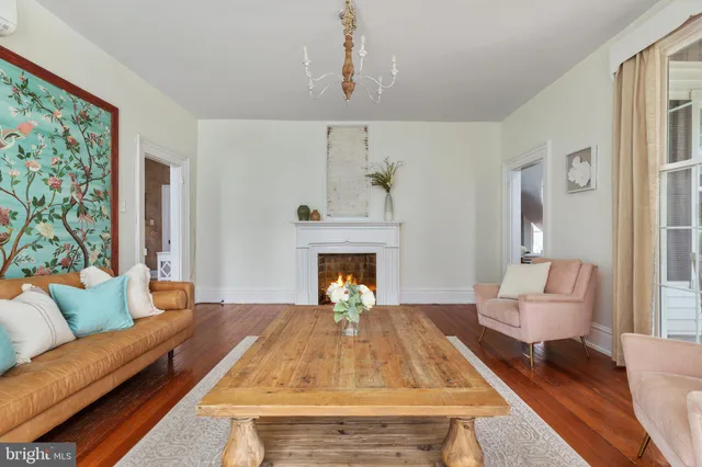 a dining room with furniture a chandelier and wooden floor