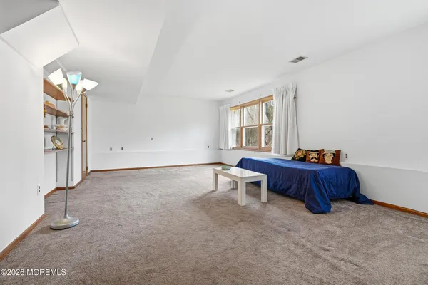 a spacious bedroom with a bed and a window