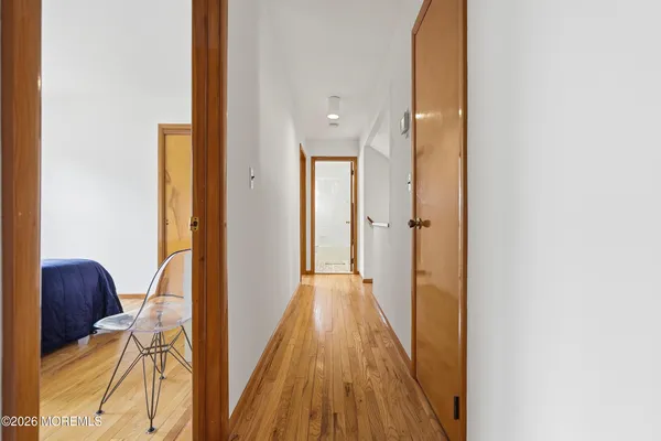 a view of a hallway with wooden floor and closet