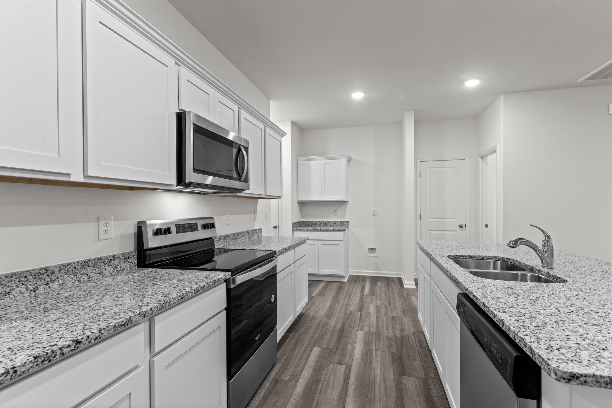 325 Spaight Acrs Way Wake Forest, NC 27587 - Photo 5 of 54 a kitchen with granite countertop stainless steel appliances sink stove microwave and cabinets