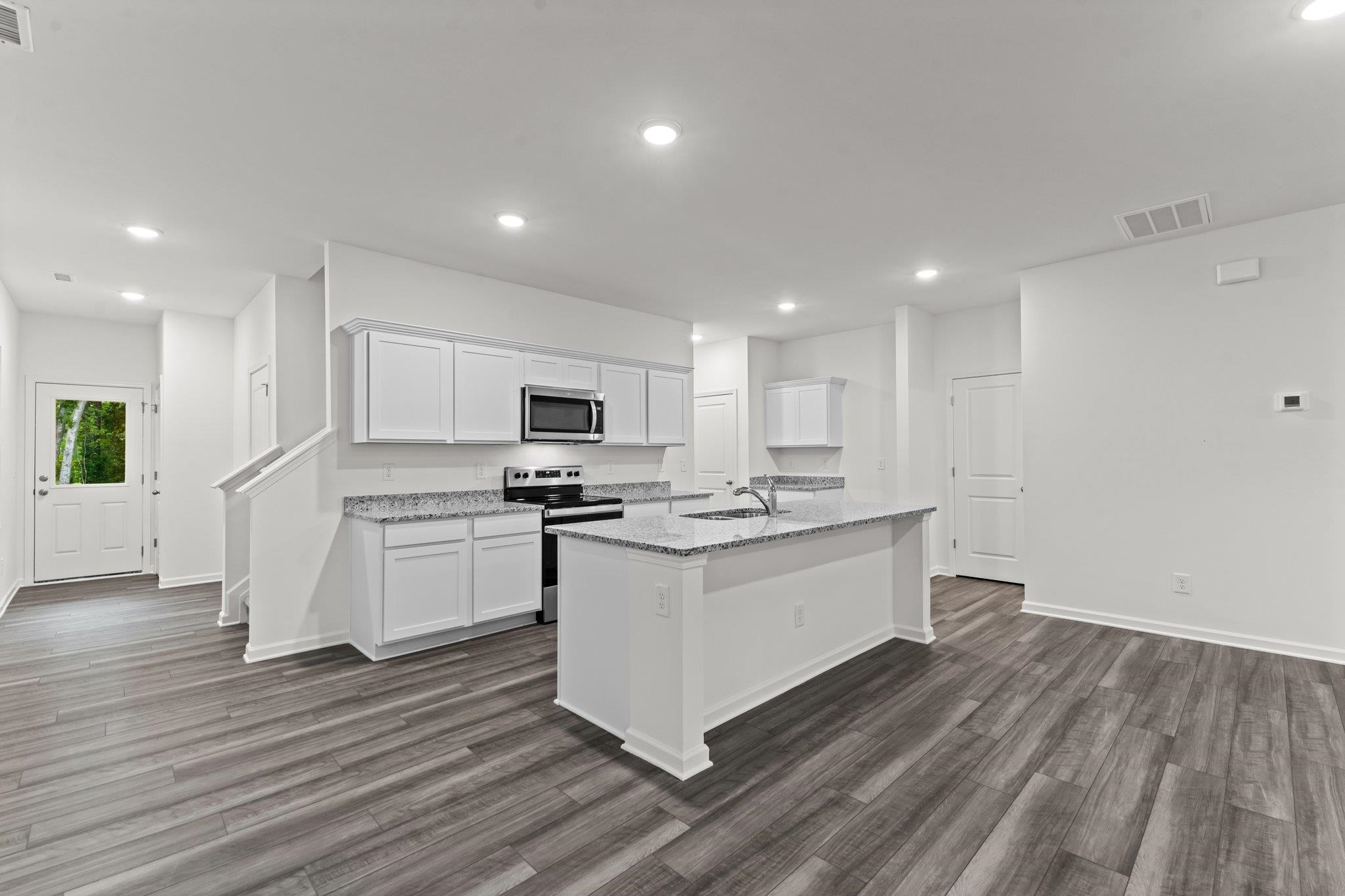 325 Spaight Acrs Way Wake Forest, NC 27587 - Photo 8 of 54 a kitchen with stainless steel appliances kitchen island granite countertop a stove a sink and a refrigerator