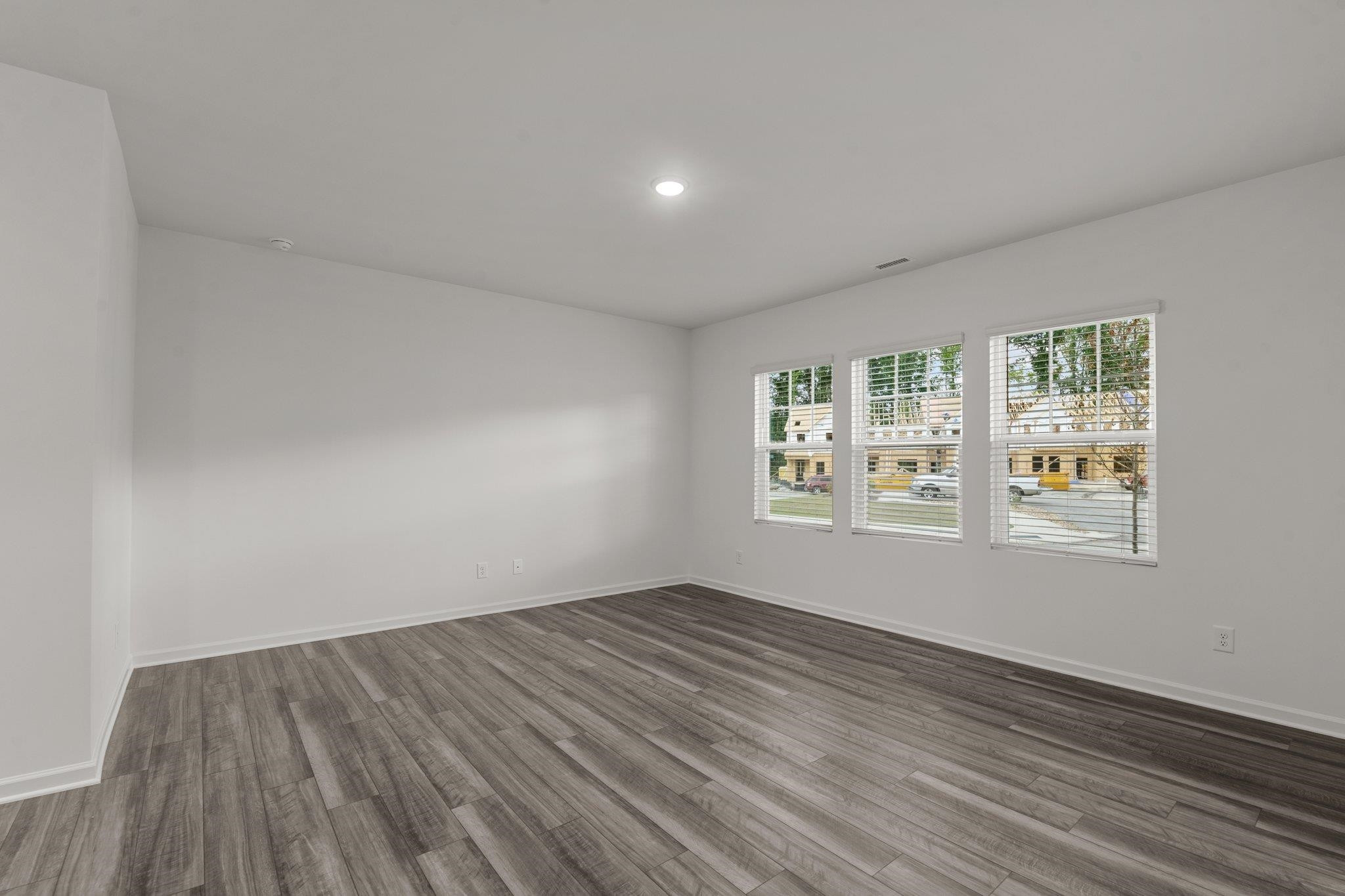 325 Spaight Acrs Way Wake Forest, NC 27587 - Photo 10 of 54 an empty room with wooden floor and windows