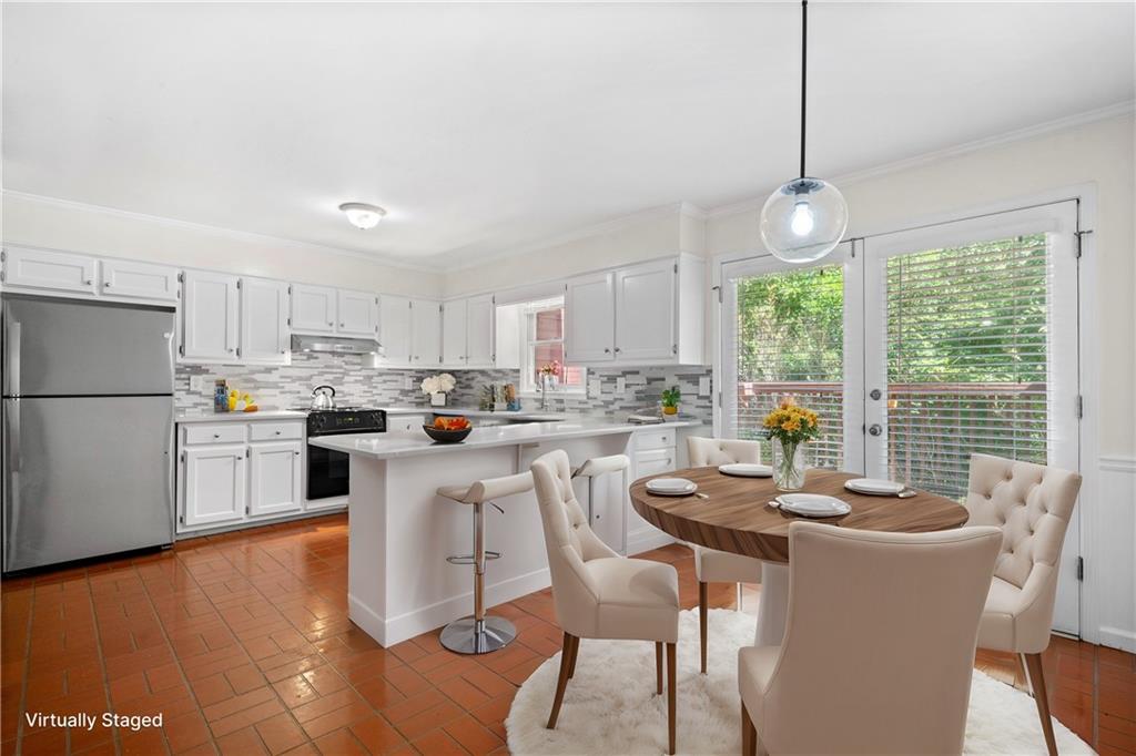 661 North Parkwood Road, Unit C Decatur, GA 30030 - Photo 2 of 14 a kitchen with a dining table chairs stainless steel appliances and cabinets