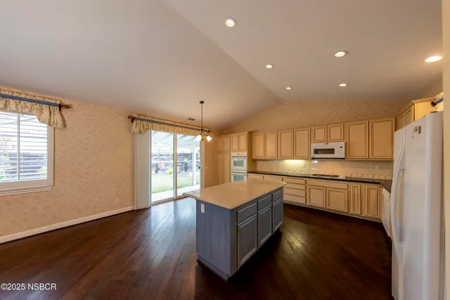 a room with kitchen island a wooden floor and a fireplace