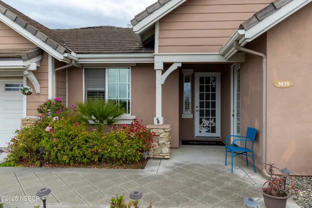 a view of a house with chair and potted plants