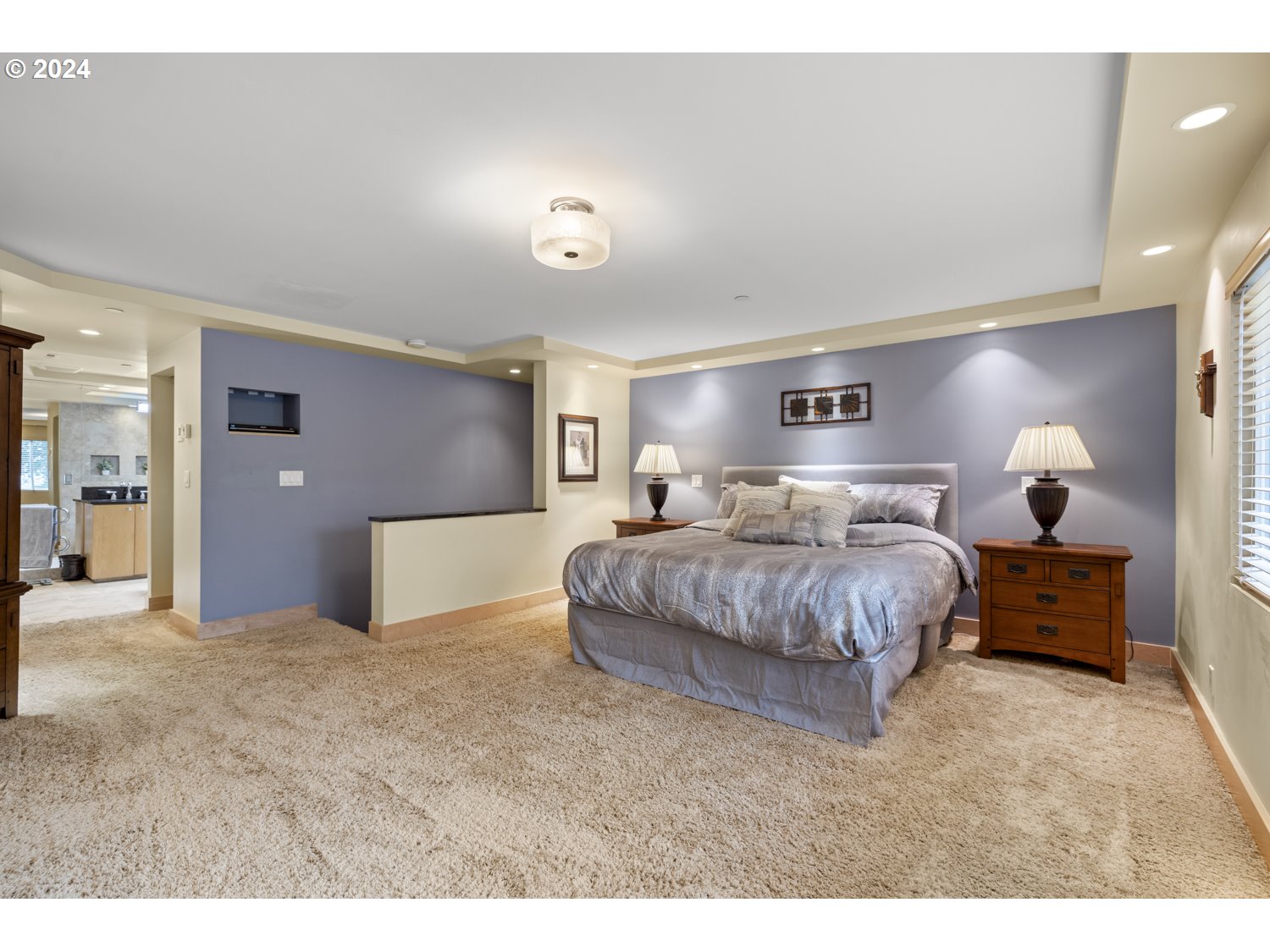 8857 Southwest Edgewood Street Tigard, OR 97223 - Photo 24 of 48 a spacious bedroom with a large bed and a chandelier