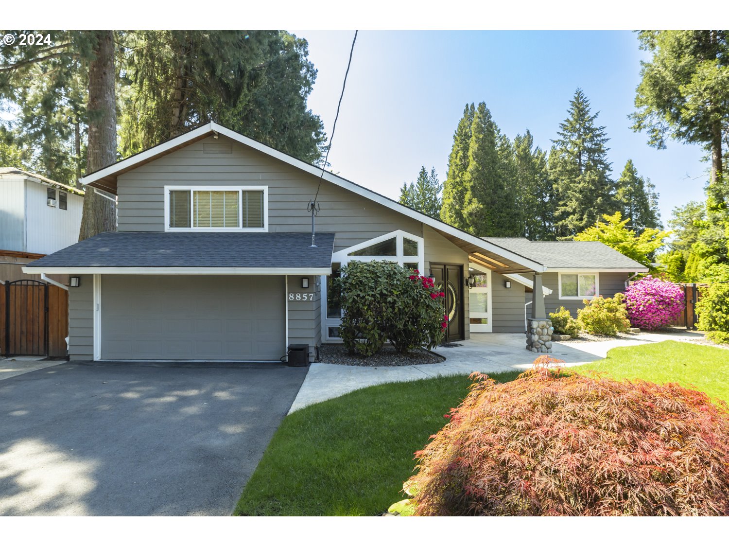 8857 Southwest Edgewood Street Tigard, OR 97223 - Photo 46 of 48 a front view of a house with a yard and garage
