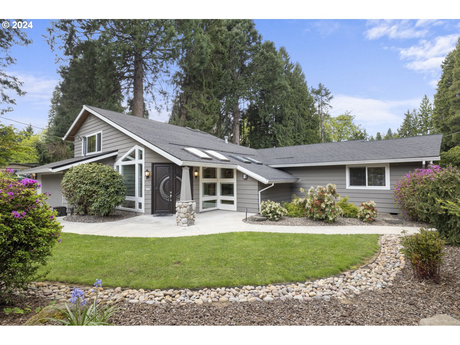 8857 Southwest Edgewood Street Tigard, OR 97223 - Photo 47 of 48 a front view of a house with a yard and trees