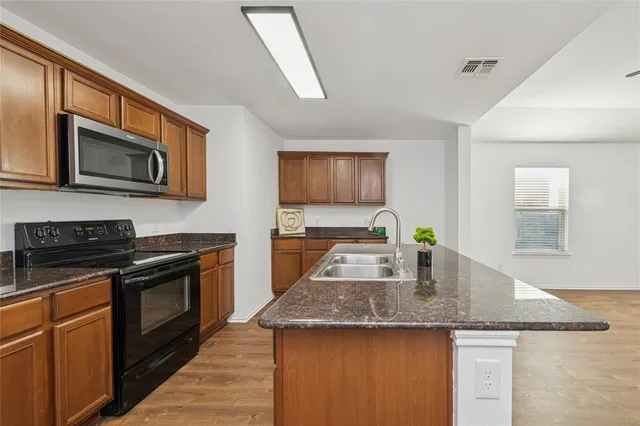 a kitchen with stainless steel appliances granite countertop a stove microwave sink and refrigerator
