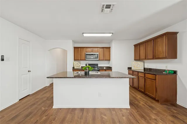 a kitchen with stainless steel appliances granite countertop a stove a sink and a refrigerator