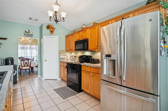 a kitchen with stainless steel appliances granite countertop a refrigerator and a stove top oven