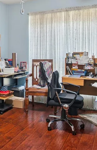 a view of a workspace with furniture and a window