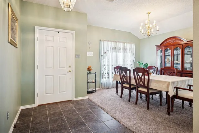 a dining room with furniture a chandelier and a rug
