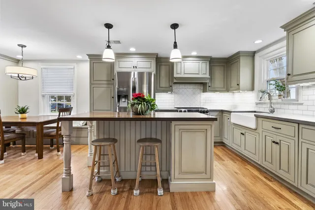 a kitchen with stainless steel appliances granite countertop a kitchen island a stove a table and chairs in it