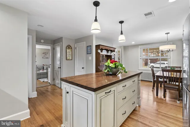 a kitchen with white cabinets and chandelier