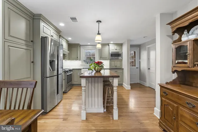 a kitchen with stainless steel appliances kitchen island granite countertop a refrigerator and a stove top oven