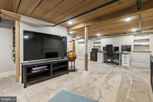 a living room with a flat screen tv and chairs
