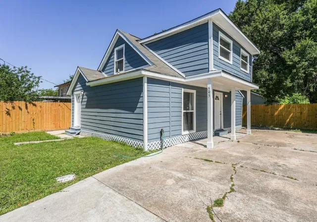 a front view of a house with a garden and yard